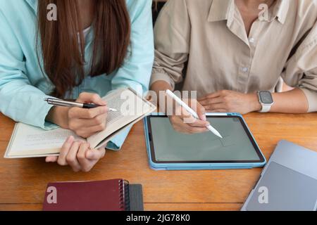 College-Bildungskonzept, weibliche Tutor Schreiben auf Tablet zu Tutoring-Unterricht für Teenager-Mädchen. Stockfoto