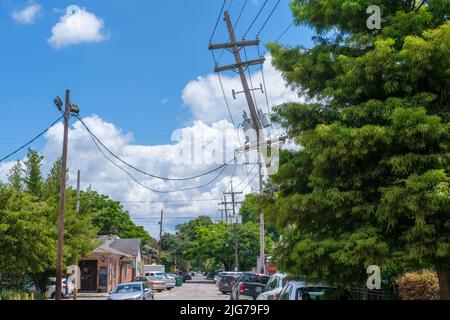 NEW ORLEANS, LA, USA - 2. JULI 2022: Stark schiefe Versorgungsmast in Uptown New Orleans Nachbarschaft Stockfoto