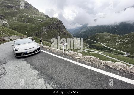 Supersportwagen Porsche 911 GT3 auf Passstraße in den Alpen nach Colle del Nivolet, rechter Hintergrund Serpentinenkurven, Col du Nivolet, Graian Stockfoto