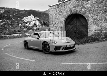 Nachstellung des klassischen Schwarz-Weiß-Fotos von Porsche 911 auf der historischen Rennstrecke der Rallye Monte Carlo 1965 mit dem modernen Supersportwagen Porsche GT3 Stockfoto