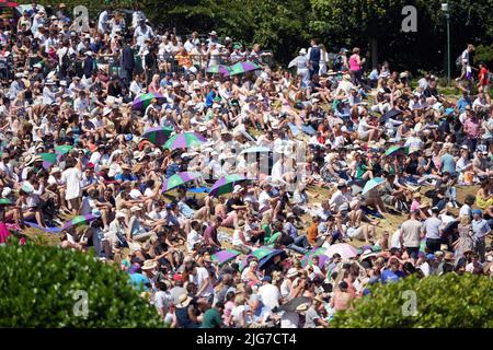 Am 12. Tag der Wimbledon Championships 2022 im All England Lawn Tennis and Croquet Club, Wimbledon, schützen sich die Zuschauer vor der Sonne. Bilddatum: Freitag, 8. Juli 2022. Stockfoto