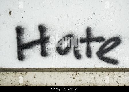Hate geschrieben/gemalt auf Betonwand. Texture, Message, Quote, Statement Concept. Stockfoto