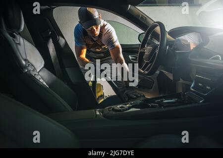 Kaukasische Männer Saugen Moderne Auto-Interieur. Fahrzeugsitze Reinigen. Fahrzeugdesign. Stockfoto