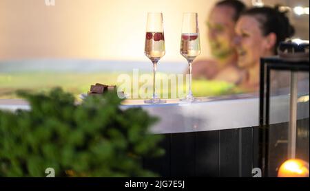 Dating Paare Entspannen im Garten-SPA. Zwei Gläser Champagner und Schokolade am Rand des Whirlpools. Stockfoto