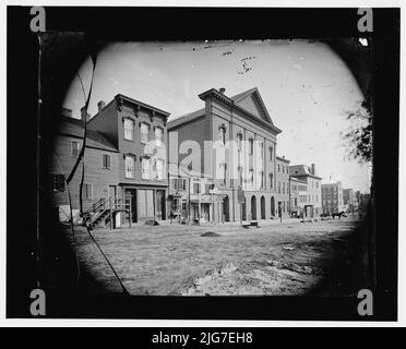 Ford's Theatre, Washington, D.C., zwischen 1860 und 1880. Ort des Attentats auf US-Präsident Abraham Lincoln am 14. April 1865. Ursprünglich als Begegnungshaus der First Baptist Church of Washington erbaut, kaufte John T. Ford die ehemalige Kirche und renovierte sie zu einem Theater. [Schilder: 'Dye House; Kimmell's Steam Dye &amp; Scheuern, Hauskleidung gereinigt &amp; gedrückt]. Stockfoto