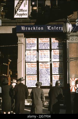 Männer und eine Frau liest Schlagzeilen posted in Straßenecke Fenster von Brockton Enterprise Zeitungsredaktion am Heiligabend, Brockton, Massachusetts, USA Stockfoto