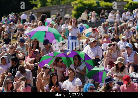 Am 12. Tag der Wimbledon Championships 2022 im All England Lawn Tennis and Croquet Club, Wimbledon, schützen sich die Zuschauer vor der Sonne. Bilddatum: Freitag, 8. Juli 2022. Stockfoto