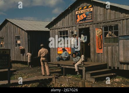 Wohnquartiere und „Juke Joint“ für Wanderarbeiter, eine lockende Saison; Belle Glade, Florida. [Schilder, die für Jax eiskaltes Bier, Royal Crown Cola und Coca-Cola werben]. Stockfoto