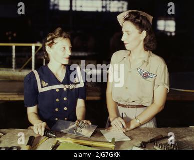 Die Witwen von Pearl Harbor sind in die Kriegsarbeit gegangen, um den Kampf mit persönlicher Rache zu führen, Corpus Christi, Texas. Frau Virginia Young (rechts), deren Ehemann einer der ersten Opfer des Zweiten Weltkriegs war, ist eine Aufsichtsperson in der Versammlungs- und Reparaturabteilung des Naval Air Base. Ihre Aufgabe ist es, bequeme und komfortable Wohnräume für Arbeiterinnen aus dem Staat zu finden, wie Ethel Mann, die eine Elektrobohrmaschine betreibt. Stockfoto