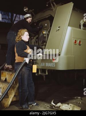 Helen Ryan, 41 Jahre alt (mit Mütze), Witwe und arbeitete früher in einer Schaufabrik, Heil and Co., Milwaukee, Wisconsin. Agnes Cliemka, 23, verheiratet und Ehemann, kann jeden Tag in den Dienst [US-bewaffnete Dienste] gehen, Bruder in der Armee. [Sie] war früher Angestellte in einem Dep[artmen]t-Laden. Entlarven und Überprüfen von Teilen der Benzinanhänger, die an die Luftwaffe überführt werden. Stockfoto