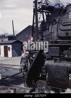 Wischerinnen der Chicago und North Western Railroad putzen eine der riesigen Lokomotiven der H-Klasse, Clinton, Iowa. Frau Marcella Hart und Frau Viola Sievers. Stockfoto