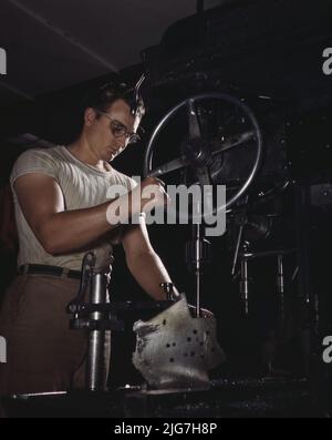 Ein Mitarbeiter im Bereich der Bohrpresse der riesigen Maschinenfabrik Nordamerikas führt Montagebohrungen in einem großen Duralguss, Inglewood, Kalifornien, durch. In diesem Werk wird der im Kampf getestete B-25 („Billy Mitchell“)-Bomber hergestellt, der bei General Doolittles Überfall auf Tokio verwendet wurde. Und das Kampfflugzeug P-51 ("Mustang"), das erstmals durch den britischen Überfall auf Dieppe in den Vordergrund gerückt wurde. Stockfoto