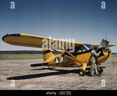 Zivilluftwaffenstützpunkt, Bar Harbor, Maine. Die Bodenbesatzung, die eine Routineüberholung eines Patrouillenflugzeugs am Hauptsitz von Coastal Patrol #20 durchführt. Das Foto zeigt das Flugzeug Stinson HW-75 oder 105 Voyager. Das Design wurde später für den Krieg auf die L-5-Wache umgestellt. Stockfoto