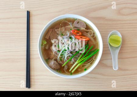 Vietnamesische Reisnudel in Porkstew-Wasser, serviert mit Salat Stockfoto