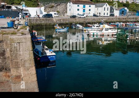 Fischerboote, die den Hafen in Porthleven, Cornwall, betreten und verlassen Stockfoto