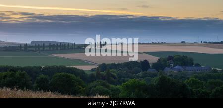 Spektakulärer Sonnenaufgang in der hügeligen Landschaft im Süden von Limburg mit Blick auf die Wiesen und auf eine Reihe von Pappelbäumen Stockfoto