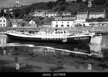 Fischerboote, die den Hafen in Porthleven, Cornwall, betreten und verlassen Stockfoto