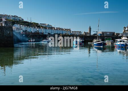 Fischerboote, die den Hafen in Porthleven, Cornwall, betreten und verlassen Stockfoto