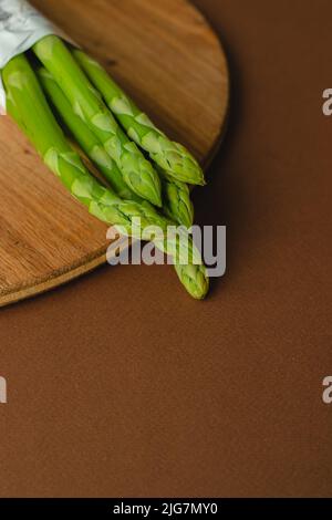 Zweige von frischem grünem Spargel auf Holzgrund, Draufsicht Stockfoto