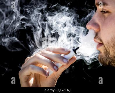 2022-07-08 11:14:10 ILLUSTRATION - Ein junger Mann raucht einen Vaper, aka eine E-Zigarette. ANP KOEN VAN WEEL niederlande Out - belgien Out Stockfoto