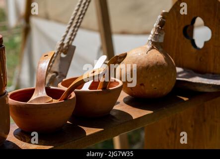 Tonschüsseln mit Holzlöffeln auf einem Regal platziert Stockfoto