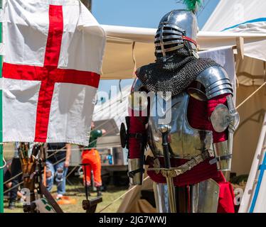 Vor einem Lagerzelt einer mittelalterlichen Ritterplatte Rüstung auf einer Schaufensterpuppe Stockfoto