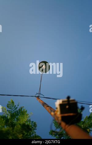 Low-Angle-Ansicht des beleuchteten Straßenlichts vor dem klaren blauen Himmel Stockfoto