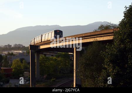 Ein Skytrain, der an einem sonnigen Sommertag auf einer Brücke in Vancouver, British Columbia, Kanada, fährt Stockfoto