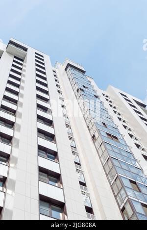 Grundansicht der Fassade eines mehrstöckigen Gebäudes mit verglasten Balkonen und Plätzen für Klimaanlagen. Neues Haus. Stockfoto