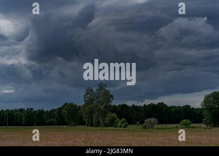 Große Regenwolken über einem landwirtschaftlichen Gebiet kurz vor einem schweren Sturm Stockfoto