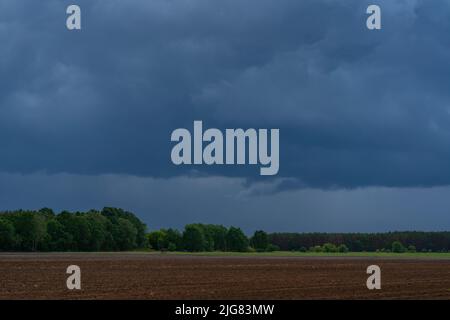 Große Regenwolken über einem landwirtschaftlichen Gebiet kurz vor einem schweren Sturm Stockfoto