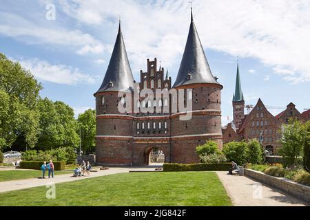 Deutschland, Schleswig-Holstein, Lübeck, Holstentor, im Hintergrund die historischen Salzlager und der Turm der St. Peter-Kirche Stockfoto