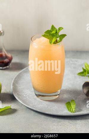 Boozy Frozen Rum Planters Punch mit Limette und Minze Stockfoto