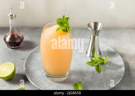 Boozy Frozen Rum Planters Punch mit Limette und Minze Stockfoto