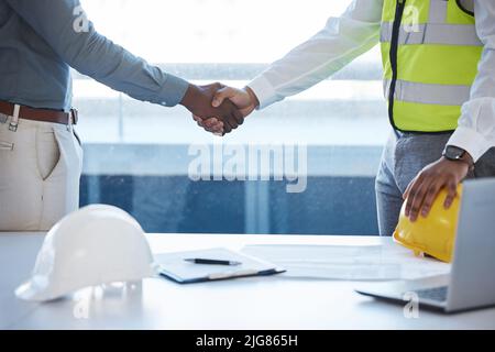 Sie werden brillant sein. Aufnahme von zwei Bauherren, die sich im Einvernehmen die Hände schüttelten. Stockfoto