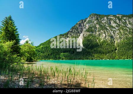 Heiterwanger See an einem sonnigen Sommertag. Alpine Berglandschaft mit Bergsee und Wäldern. Tyrol Zugspitz Arena, Tirol, Österreich, Europa Stockfoto