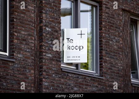 2022-07-08 16:01:37 AMSTERDAM - Wohnungsangebot in einem Fenster einer Immobilienagentur. Die Zahl der zum Verkauf stehenden Häuser nimmt rapide zu. ANP RAMON VAN FLYMEN niederlande Out - belgien Out Stockfoto