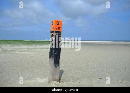 Strand mit rotem Strandmast an einem riesigen, stürmischen Strand Stockfoto