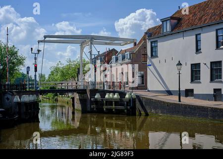 Stadtbild von Oudewater, Niederlande. Gelegen am Fluss Hollandsche IJssel. Blick auf alte Häuser, Fluss, Kanal und mittelalterliche Kirche. Provin Stockfoto