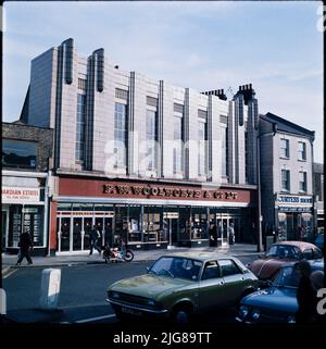 F W Woolworth and Company Limited, 612-614 Lea Bridge Road, Leyton, Waltham Forest, Greater London Authority, 1970s. Die Lea Bridge Road Höhe des F W Woolworth and Co Ltd Stores an der 612-614 Lea Bridge Road, von Norden aus gesehen. Das Geschäft an der Lea Bridge Road hatte ursprünglich die Nummer Store 129 und wurde 1923 eröffnet. Es wurde im Jahr 2000s als Woolworth's Store 2024 umnummeriert. Das Gebäude hat zwei Fassaden, die Haupthöhe auf der Lea Bridge Road, wie auf diesem Foto gezeigt, und einen kleineren Eingang auf der High Road im Nordosten. Das Geschäft schloss 2008 und das Gelände wurde später zu einem isländischen Geschäft. Stockfoto