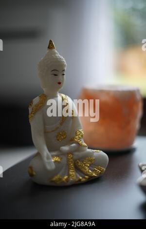 Eine Nahaufnahme einer weißen Buddha-Statue auf einem Tisch Stockfoto