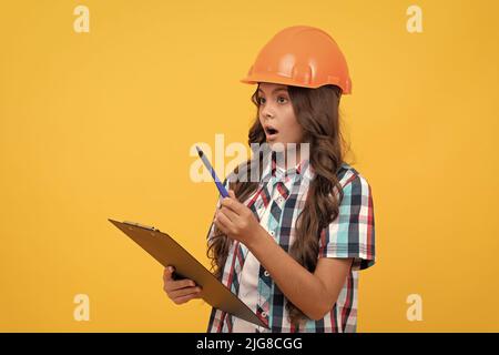 Sicherheit Arbeit Expertise. Stauned Mädchen in schützenden Hut machen Notizen. Stockfoto