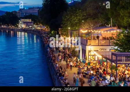 Wien, Donaukanal, Menschen sitzen auf Bank Verstärkung, Outdoor-Restaurants und Bars in 01. Bezirk Altstadt, Wien, Österreich Stockfoto