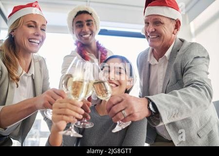Erste Schritte in den Urlaub. Aufnahme einer Gruppe von Geschäftskollegen, die in einem Büro einen feierlichen Drink zu sich nehmen. Stockfoto