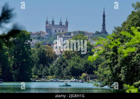 Blick auf die Basilika Unsere Liebe Frau von Fourviere durch Bäume mit See des goldenen Kopf Park im Vordergrund in Lyon, Frankreich. Stockfoto