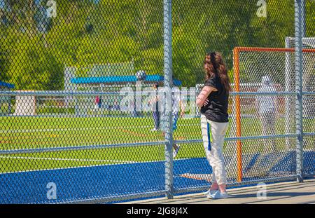 Sommeraktivitäten für Schüler. Kinder spielen Fußball, Fußball und Trainer, Lehrer trainieren sie im Freilichtstadion an sonnigen Tagen. Straßenfoto, s Stockfoto