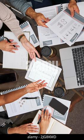 Das Beste der Besten zusammenbringen. Aufnahme eines Teams von Geschäftsleuten, die bei einem Meeting mit einem digitalen Tablet und einem Laptop zusammenarbeiten. Stockfoto