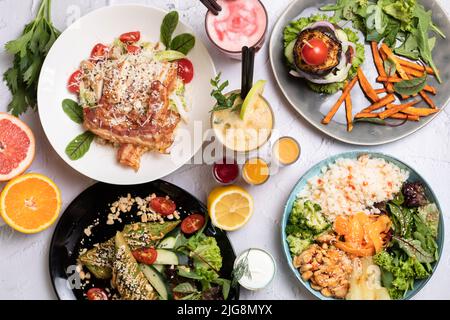 Weißer Tisch mit gesunden Mahlzeiten und Frühstück auf weißem Hintergrund. Leckeres Essen, Wandtapper verschiedene bunte Mahlzeiten zum Frühstück oder Mittagessen Stockfoto