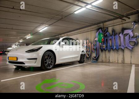 Tesla steht an der elektrischen Ladestation, Tiefgarage, Amsterdam, Niederlande Stockfoto