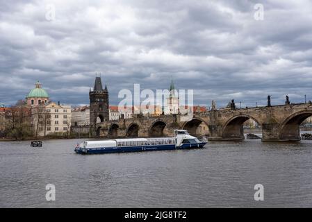 Touristenboot auf der Moldau, Karlsbrücke, Altstädter Brückenturm, Kirche des Heiligen Kreuzes, Prag, Tschechische Republik Stockfoto